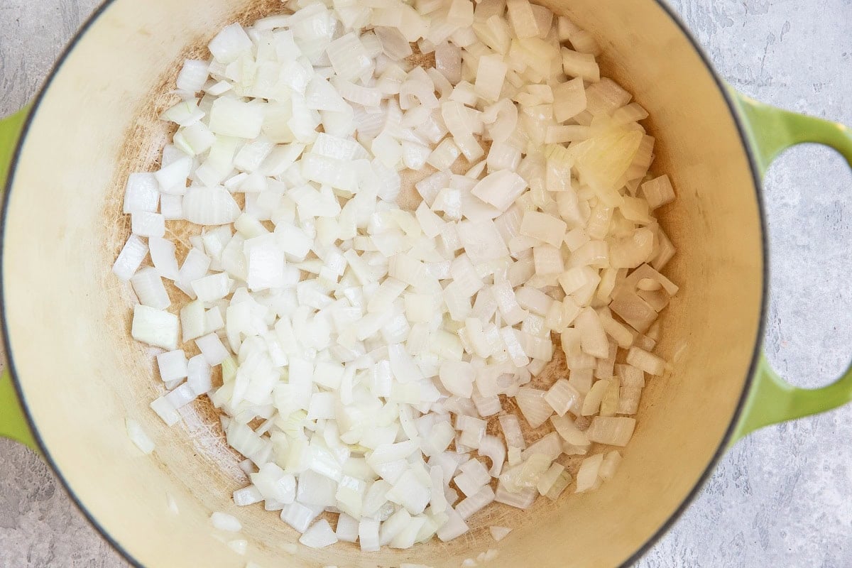 Yellow onion sautéing in a large pot.