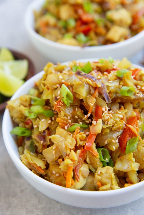 Two white bowls full of Thai cabbage and chicken.