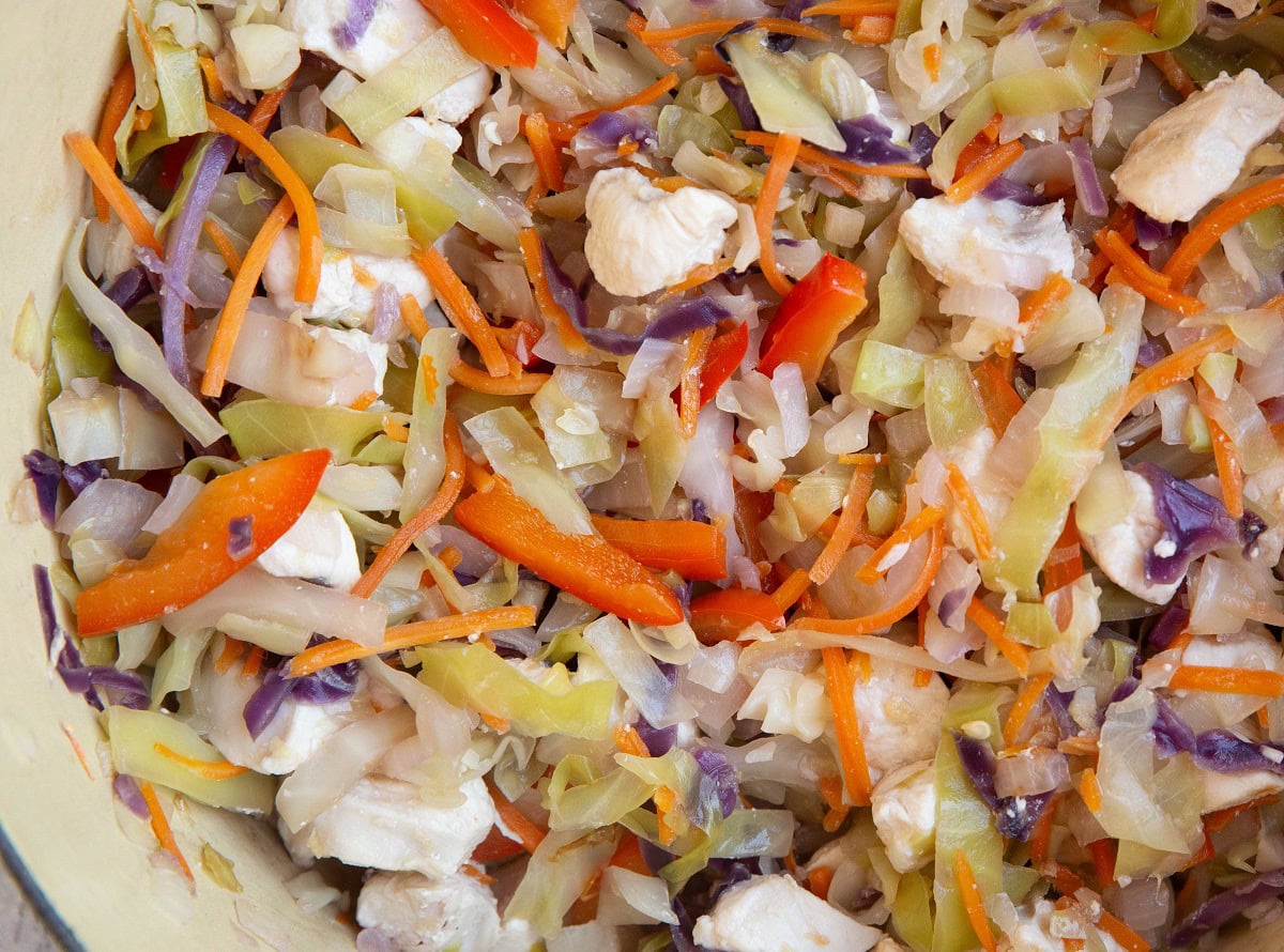 Chicken and vegetables cooking in a large pot.