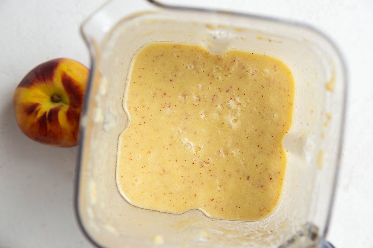 Peach popsicle mixture in a blender, ready to be turned into popsicles