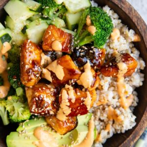 Wooden bowl of salmon bites and veggies.
