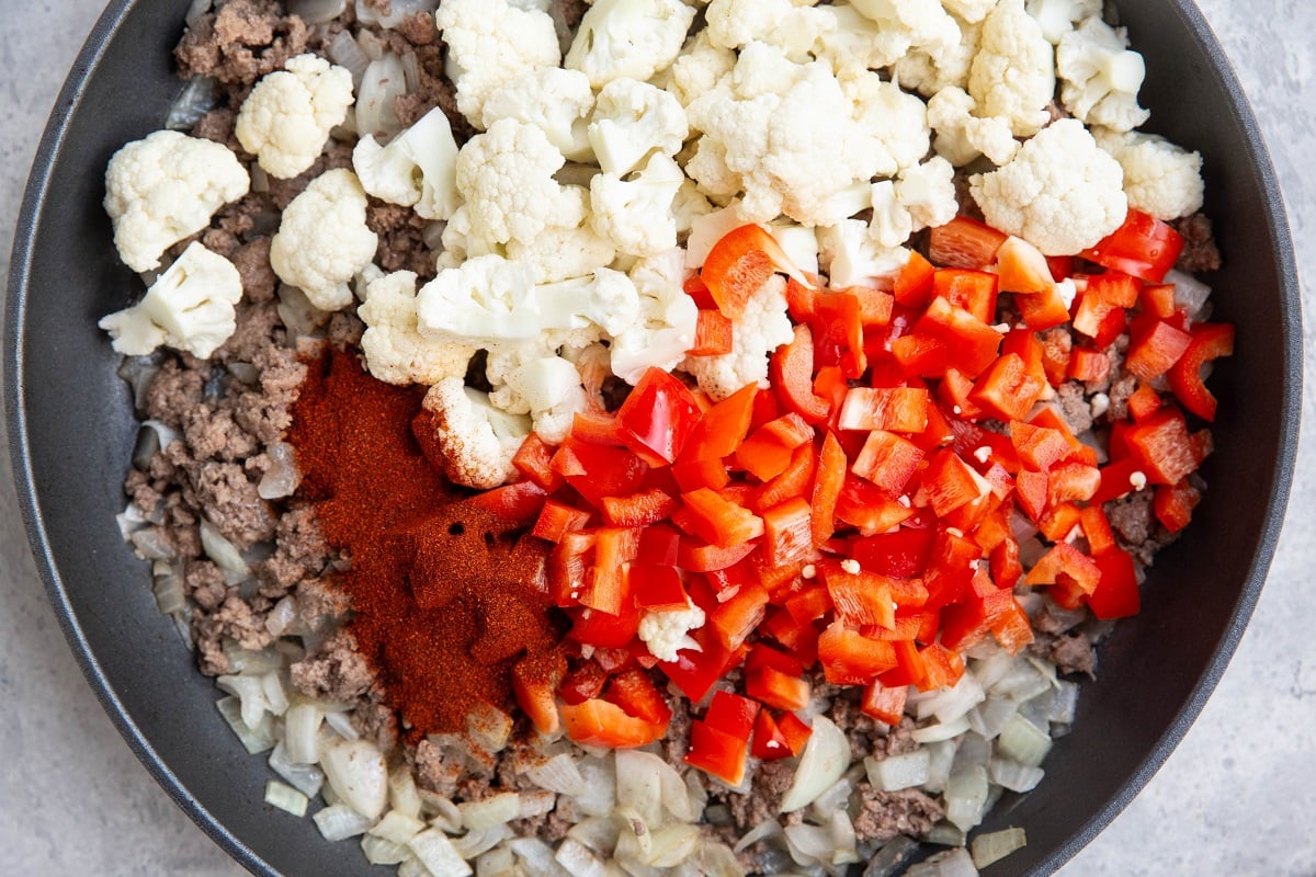 Ground beef, onions, cauliflower, red bell pepper and chili powder in a large skillet.