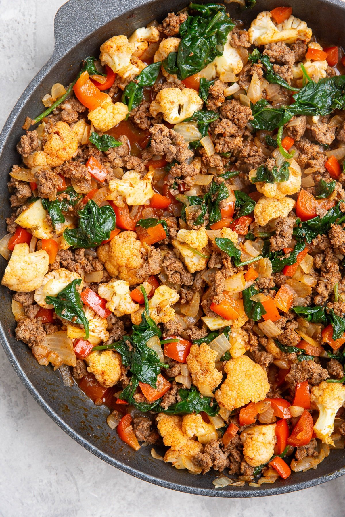 Ground beef and vegetables in a skillet, ready to serve.