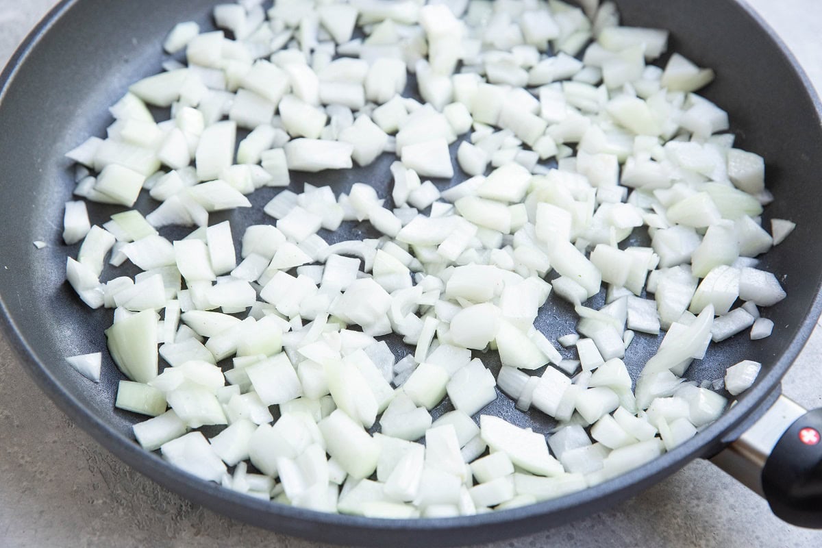 Onion sautéing in a large non-stick pan