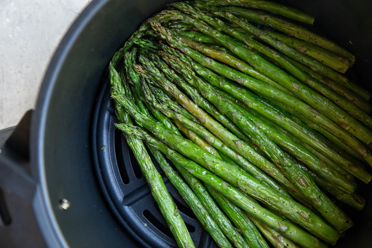 Cooked asparagus in an air fryer, ready to serve.