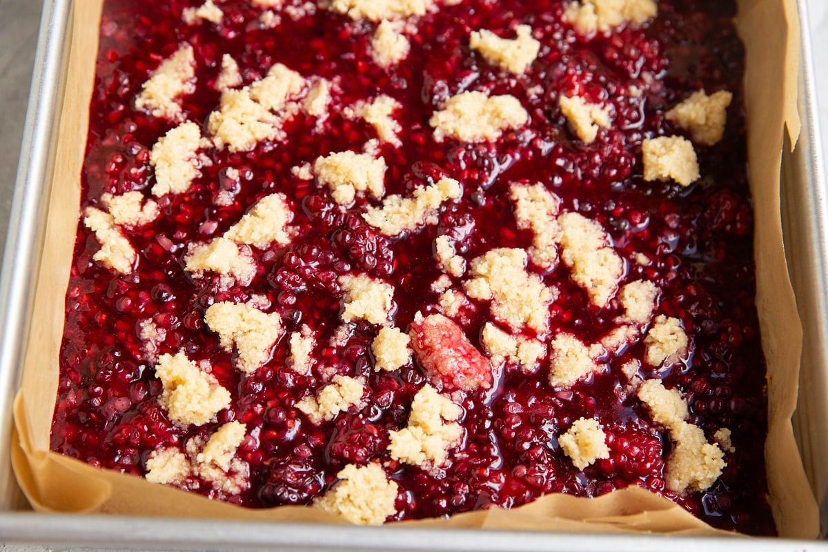 Crumble topping on top of blackberry layer to form the bars. Ready to go into the oven.