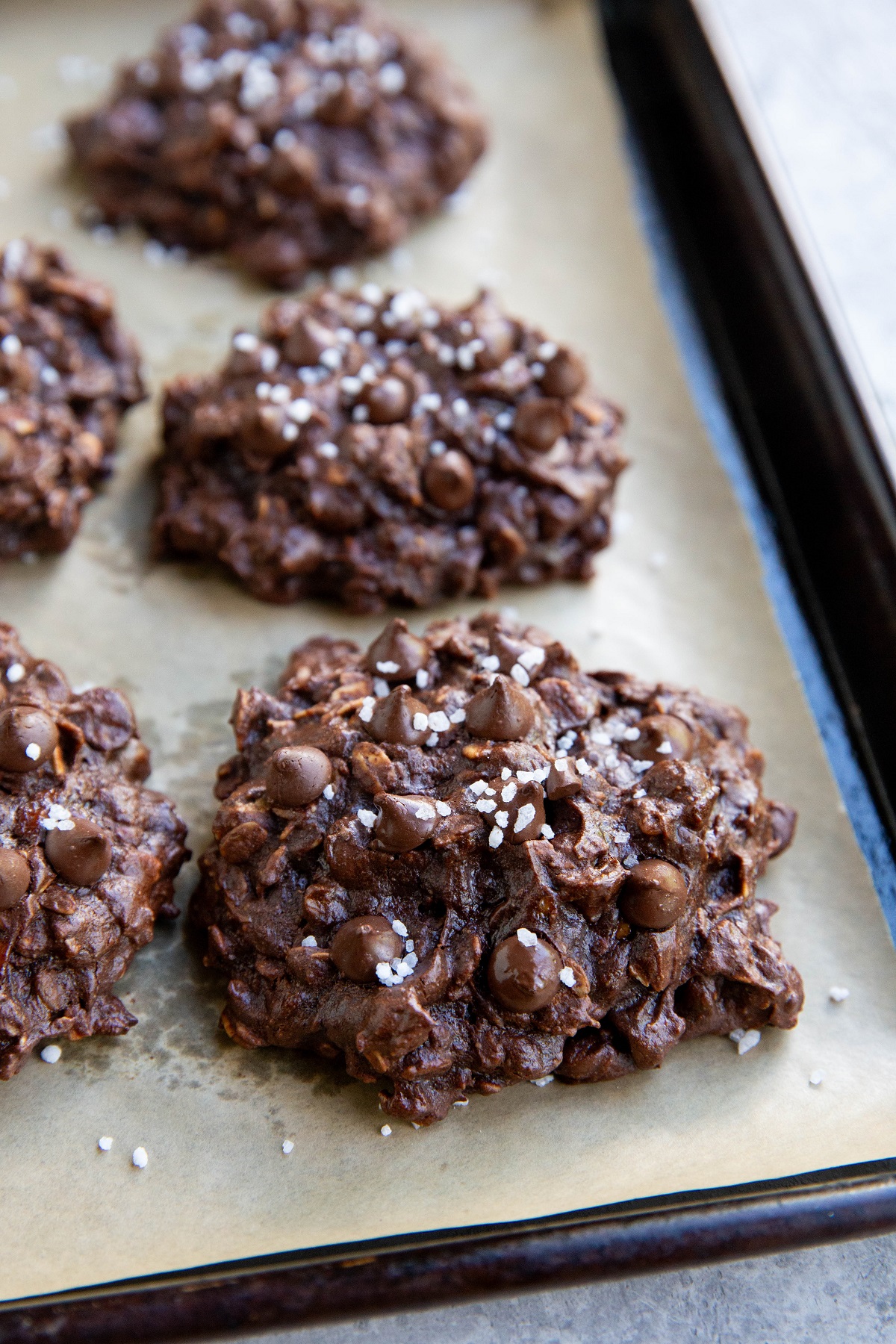 Finished double chocolate oatmeal cookies on a baking sheet, ready to eat.