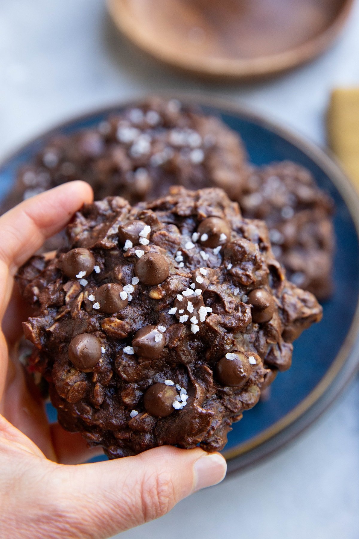 Hand holding a double chocolate chip cookie.