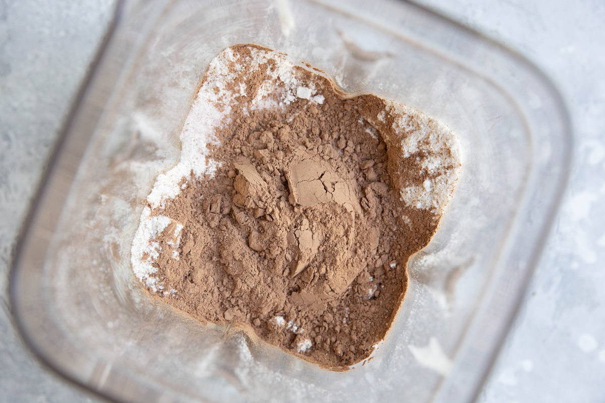 cocoa powder on top of oat flour in a blender.