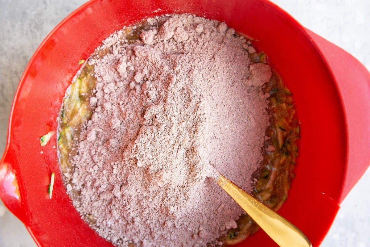 Cocoa flour mixture on top of the wet ingredients in a mixing bowl, ready to be mixed in.