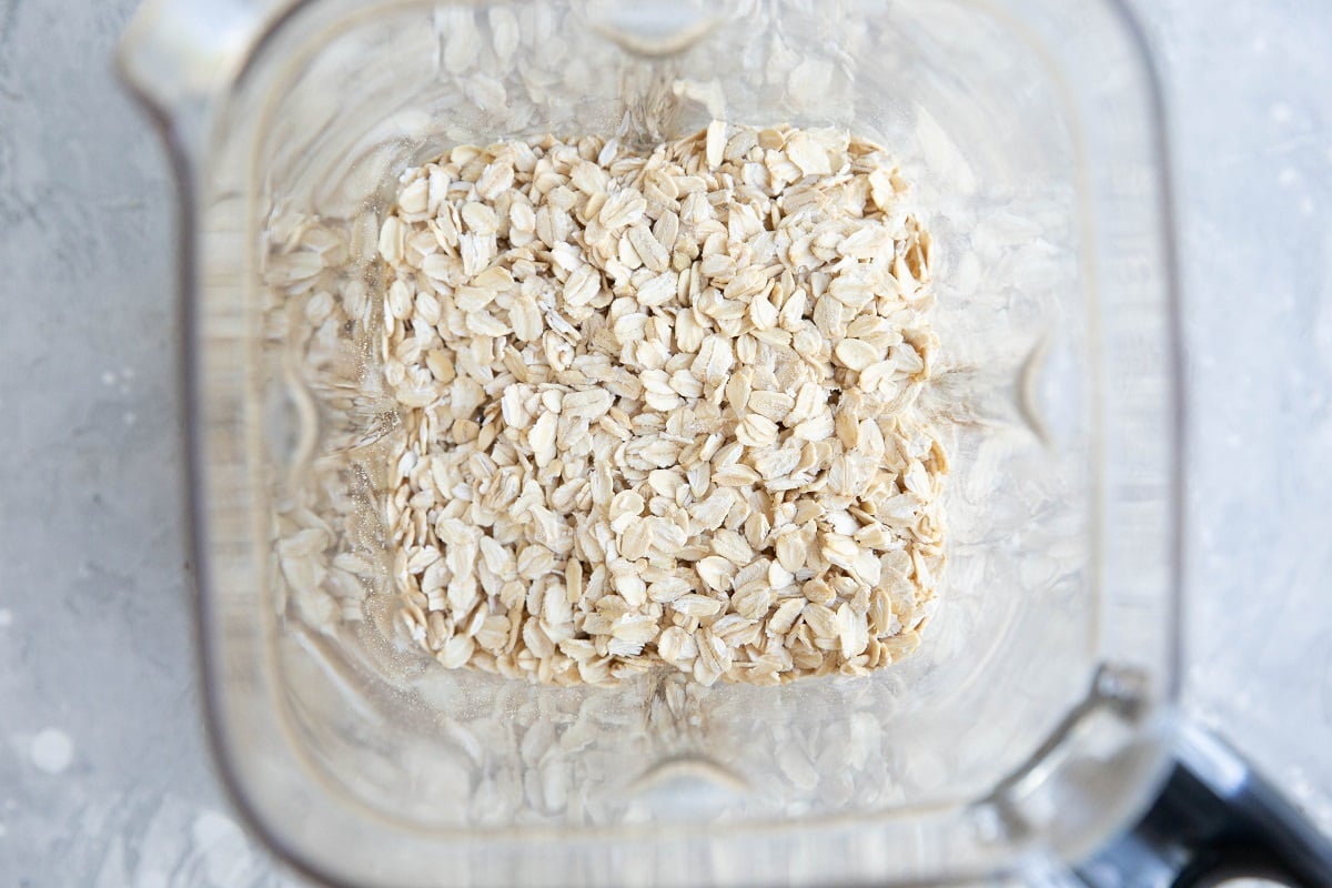 Rolled oats in a blender, ready to be blended into a flour.