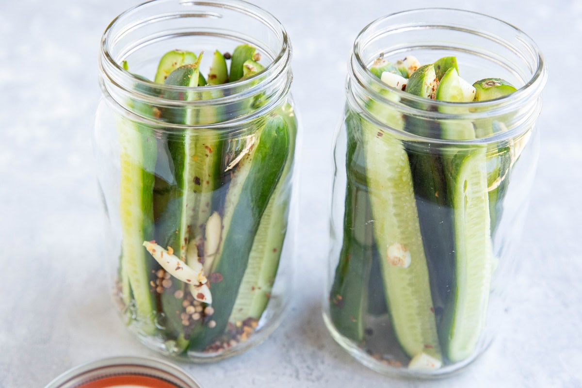 Dill pickle ingredients in two quart-sized jars