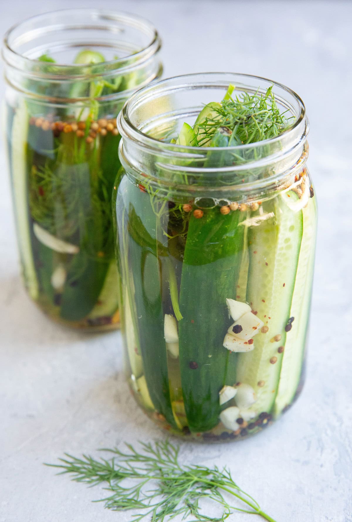 Two jars of pickles, ready to be refrigerated.