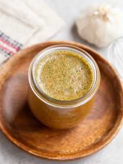 Jar of chicken marinade sitting on a wooden plate, ready to be used.