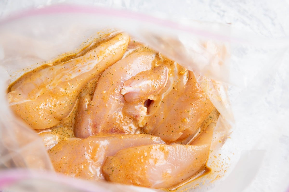 Chicken tenders in marinade in a zip lock bag.