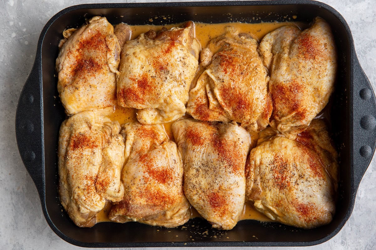 Baking pan with marinated bone in chicken, ready to be baked.