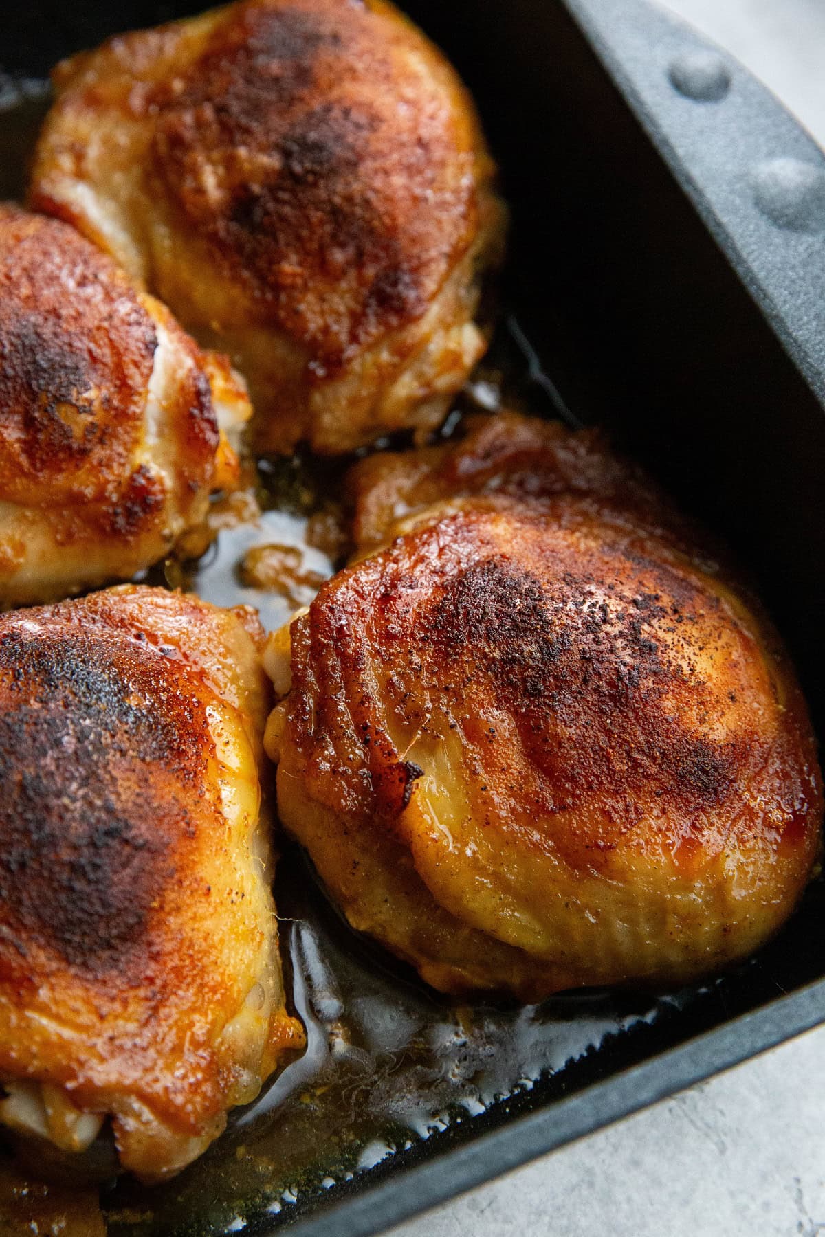 Bone in chicken thighs in a baking dish, fresh out of the oven.