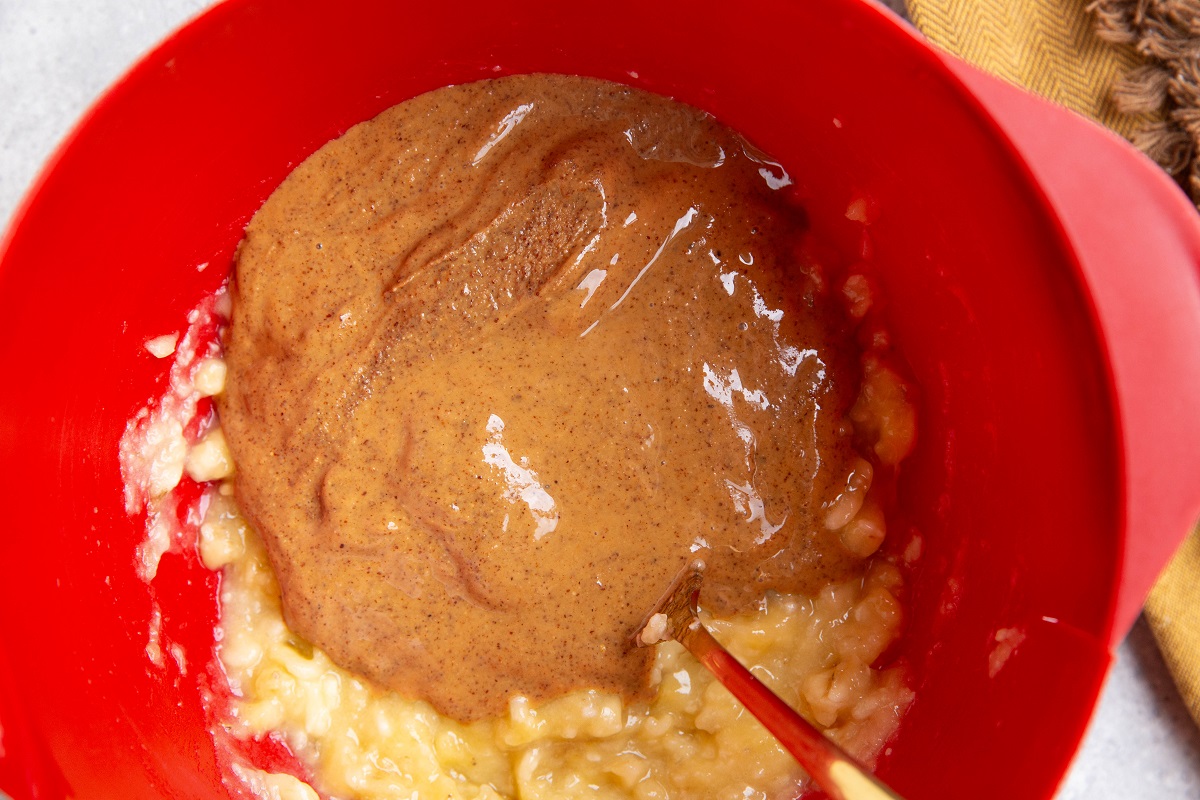 Almond butter and mashed bananas in a mixing bowl, ready to be stirred together.