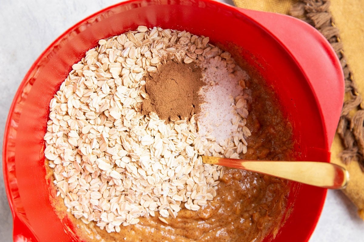 Oats, ground cinnamon, and sea salt on top of the wet mixture to make blueberry oatmeal breakfast bars.