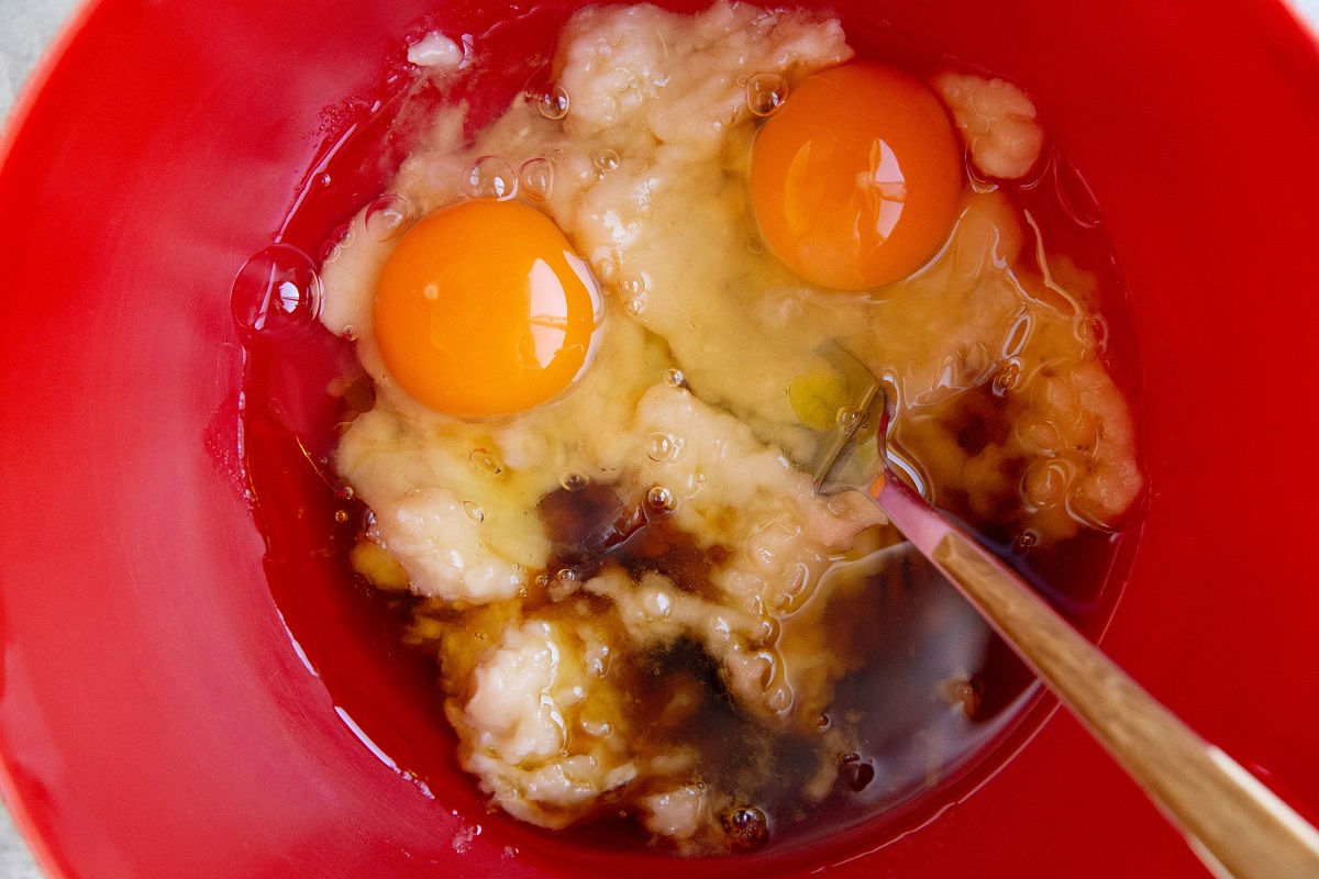 Eggs, pure maple syrup and bananas in a mixing bowl for the wet ingredients for morning glory bread.