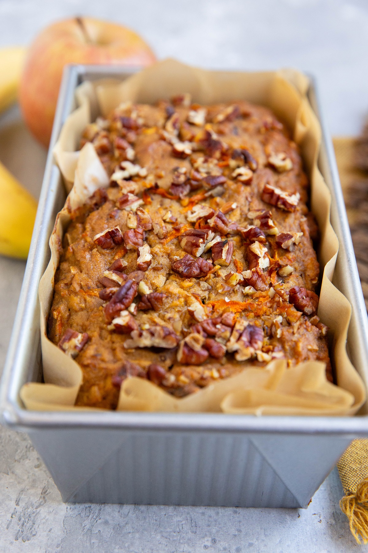 Morning glory quick bread in a loaf pan, fresh out of the oven.