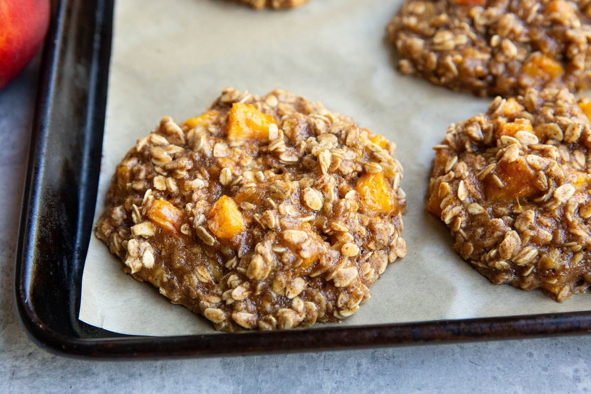 Finished peach cookies on a baking sheet, fresh out of the oven.