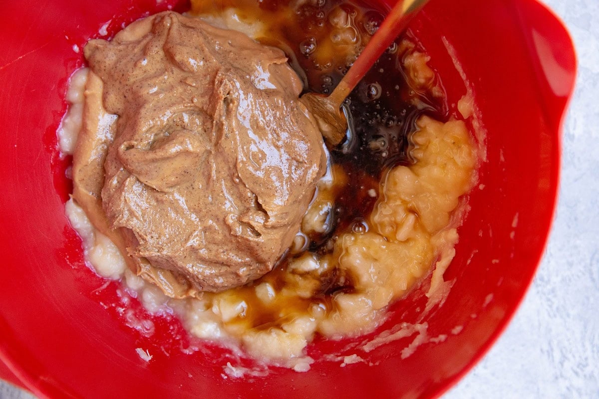 Wet ingredients for strawberry cookies in a red mixing bowl.