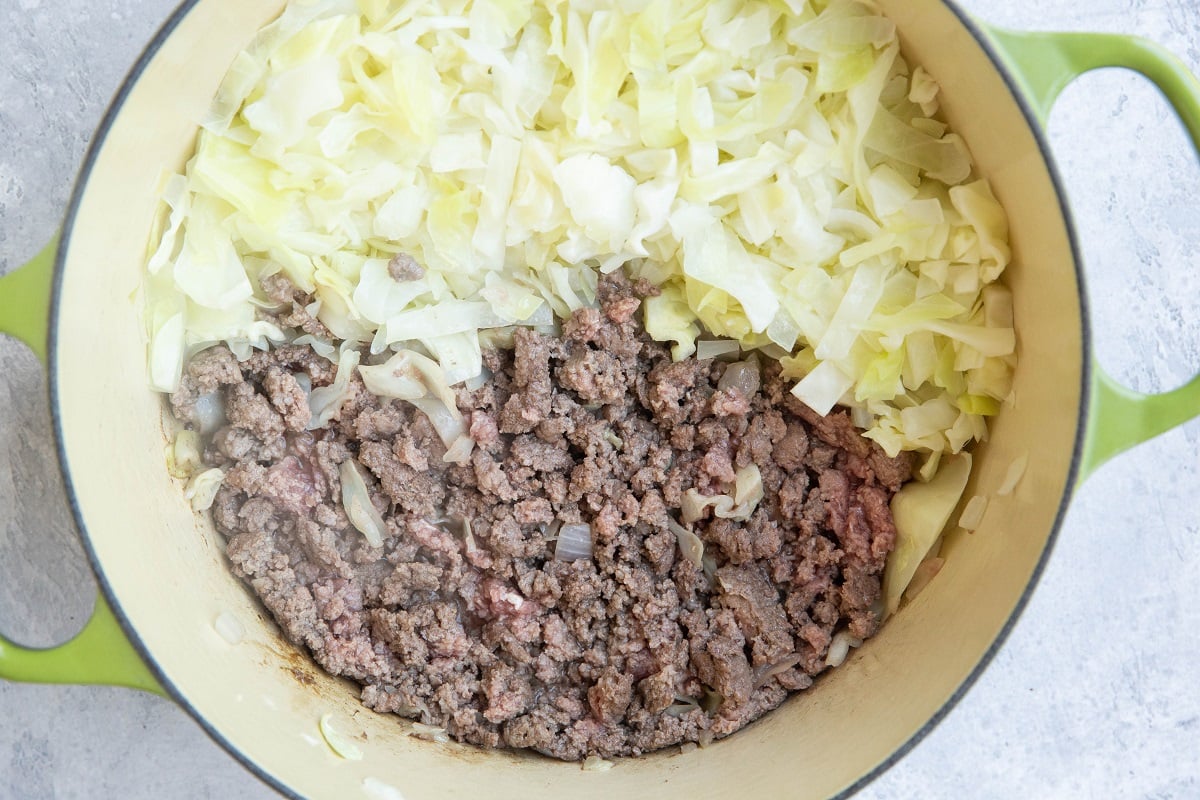 Ground beef and cabbage cooking in a large pot.