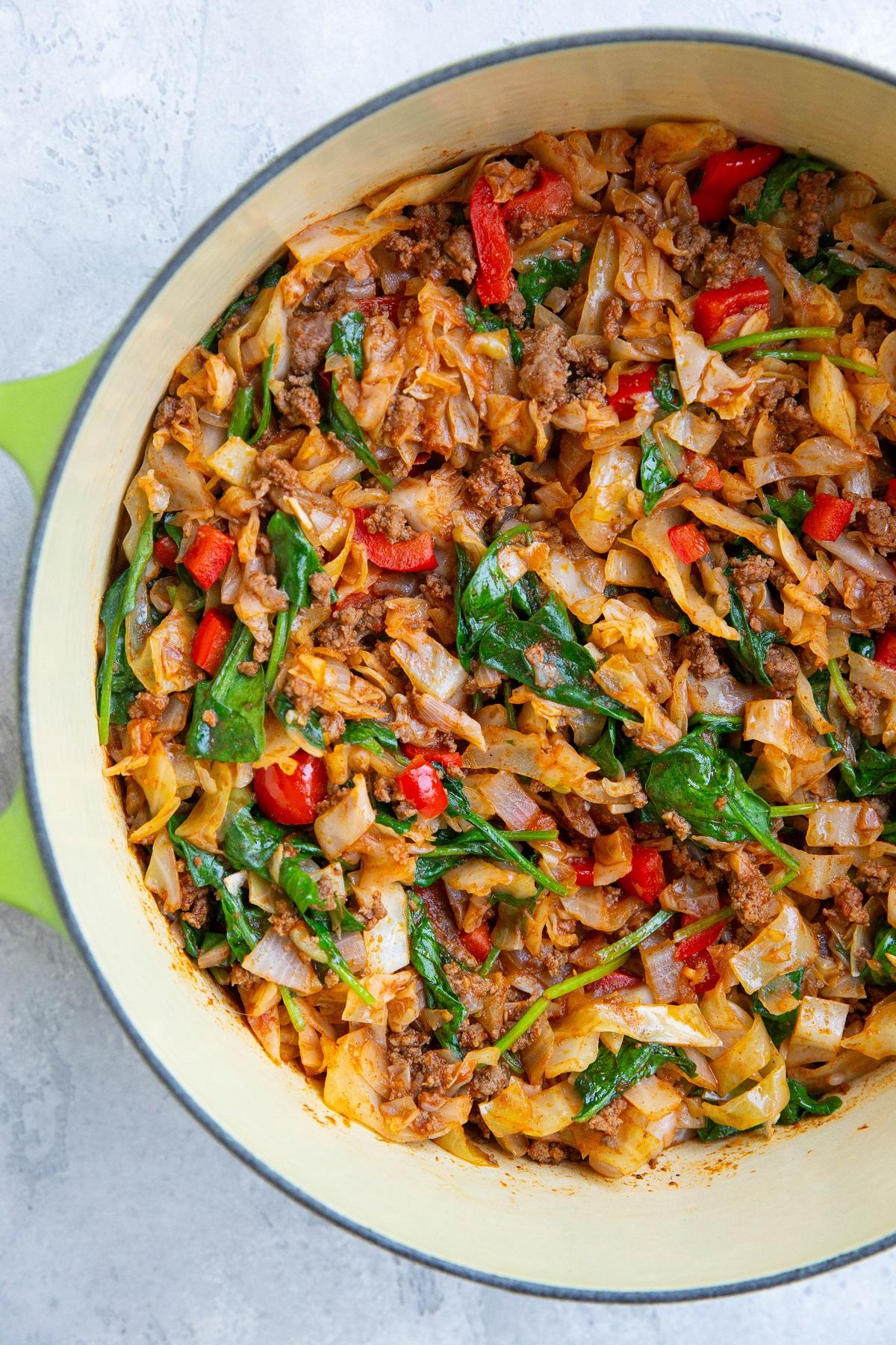 Large pot of ground beef and cabbage with vegetables and seasonings.