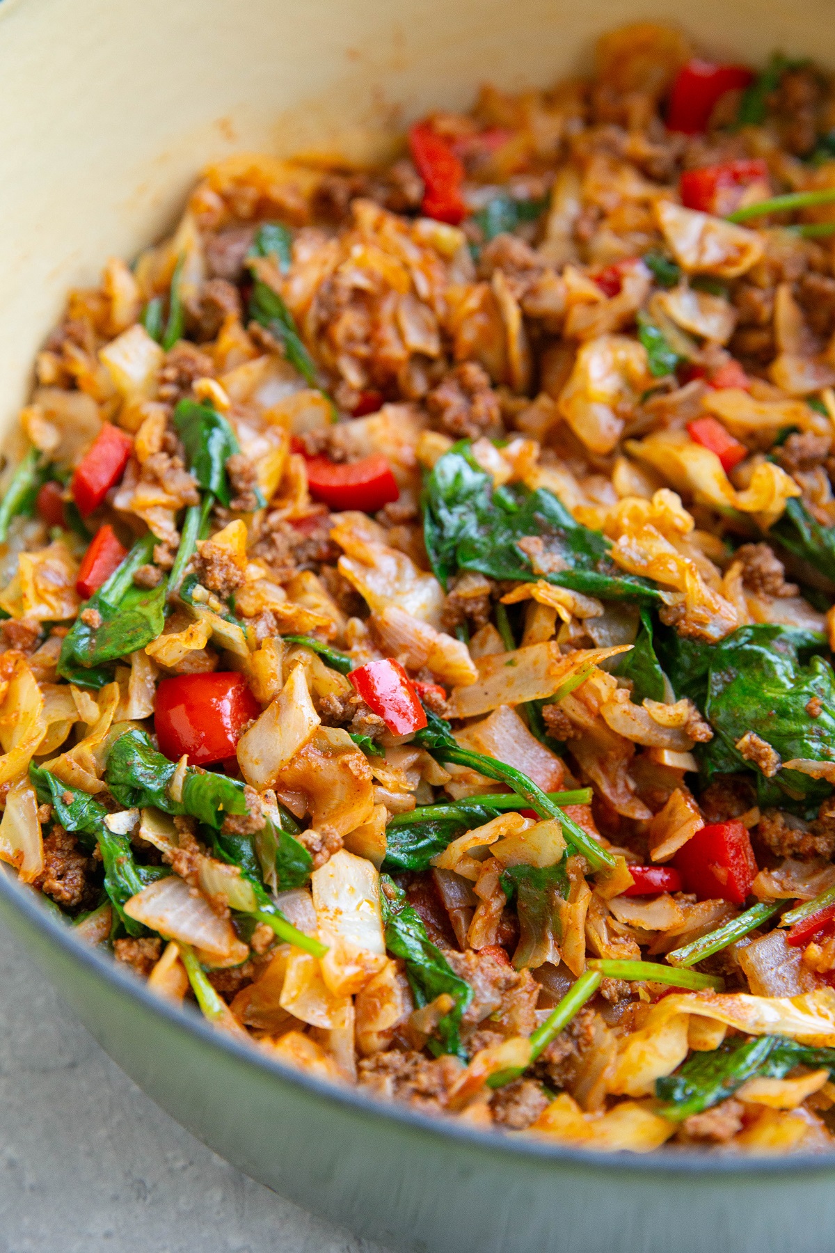 Large pot of ground beef and cabbage with other vegetables and seasonings.