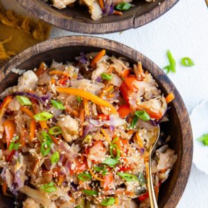 Two wooden bowls of chicken and vegetables, ready to eat.
