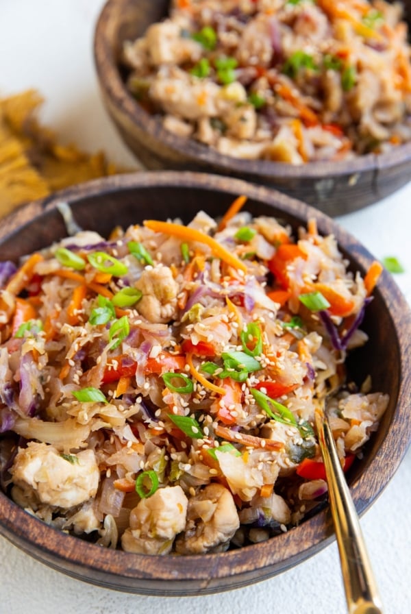 Two wood bowls of teriyaki chicken and veggies.