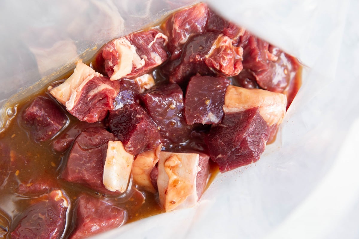 Chunks of steak in a zip lock bag with teriyaki marinade.