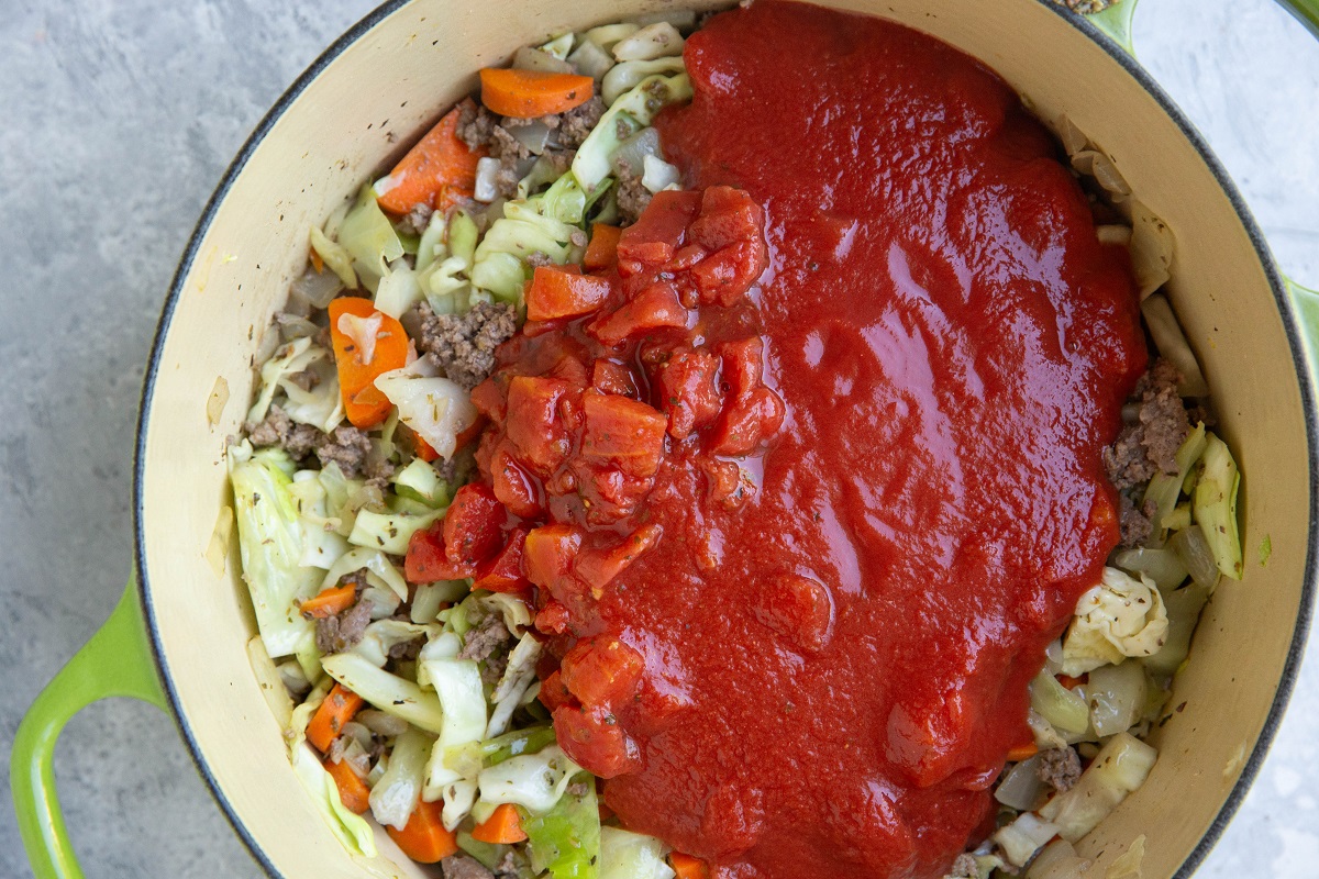 Tomato sauce, cabbage, carrots, onions and beef in a stock pot.