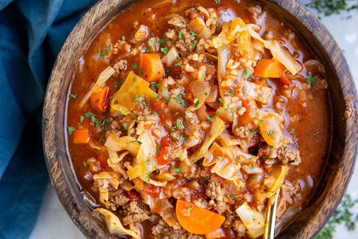 Wooden bowl of unstuffed cabbage roll soup.