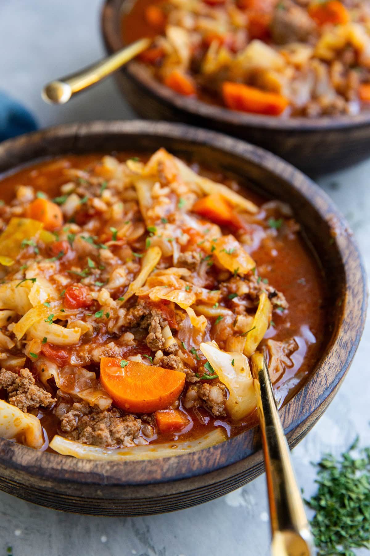 Two wooden bowls of cabbage roll soup.