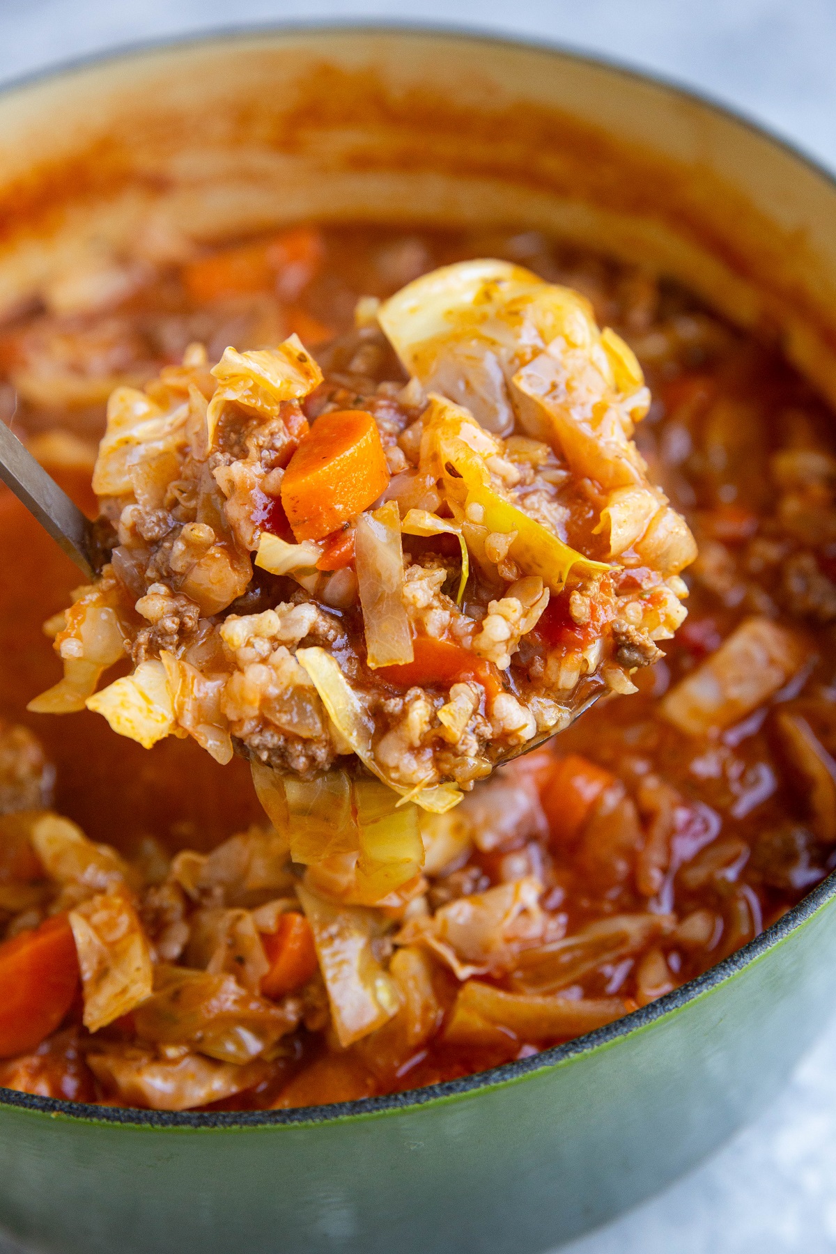 Large pot of cabbage roll soup with a ladle ladling some of it out.