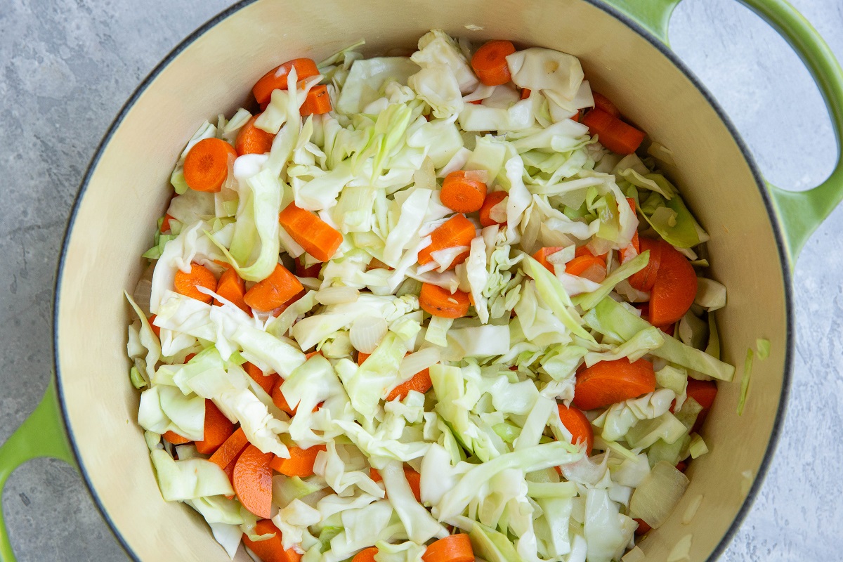 Cabbage, carrots, and onions cooking in a big pot.