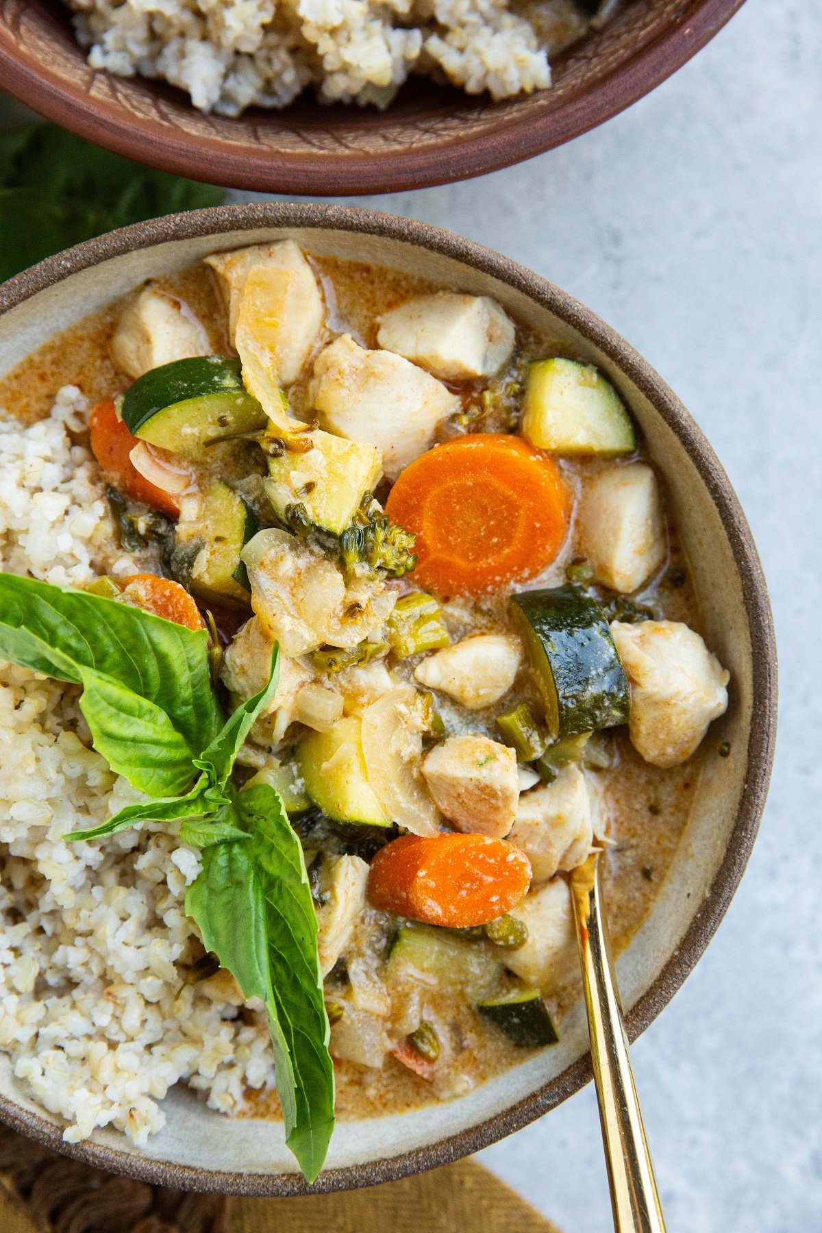 Bowl of red curry with chicken and vegetables.