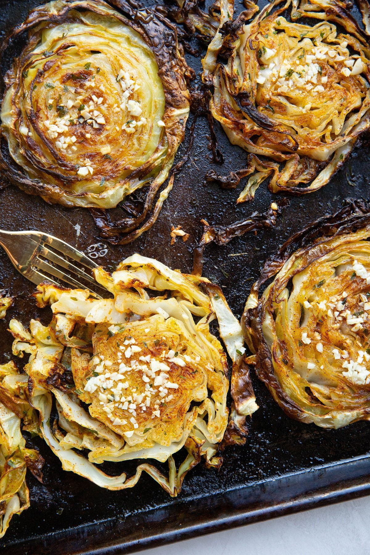 Baking sheet with roasted cabbage steaks fresh out of the oven.