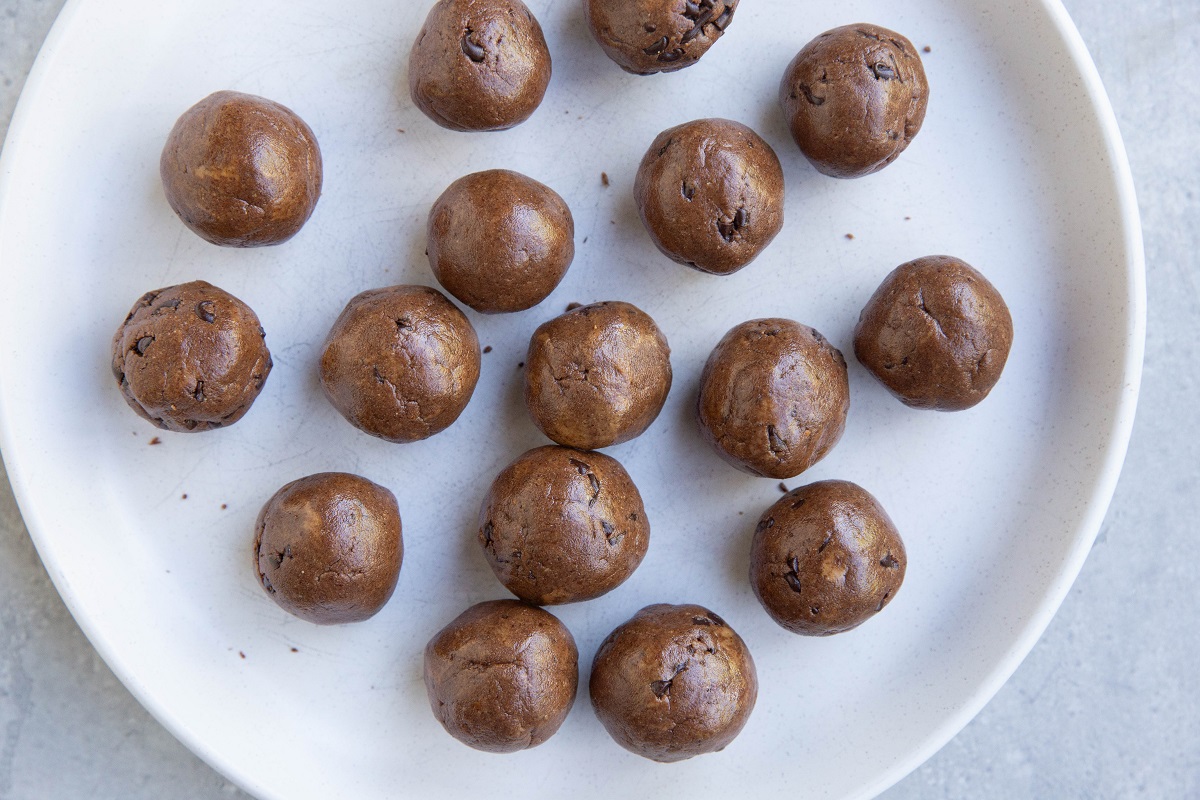 Brownie bite balls on a white plate, ready to eat.