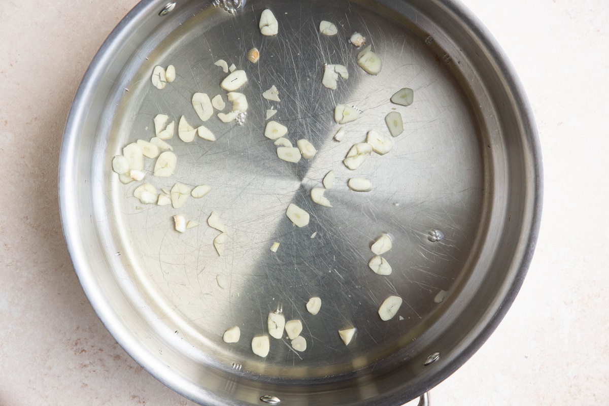 Poaching liquid and garlic in a large skillet