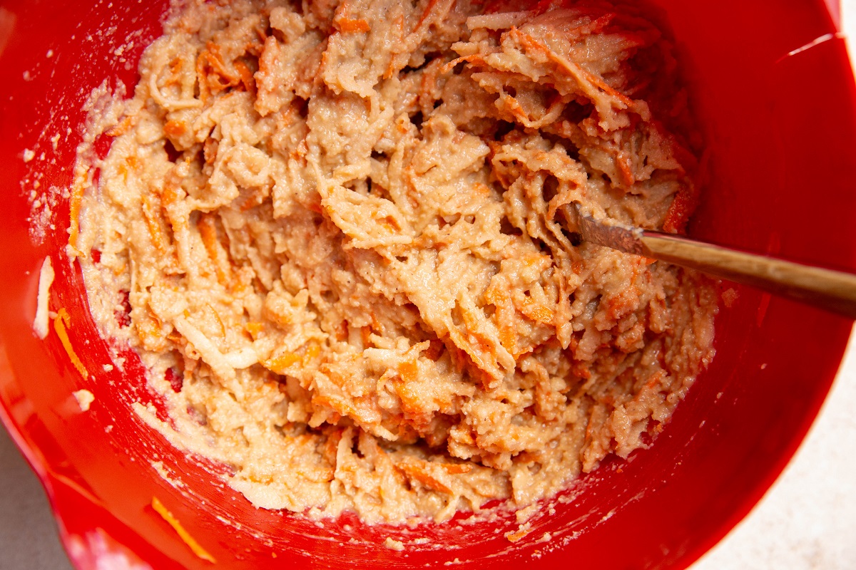 Apple carrot muffin batter in a mixing bowl, ready to bake.