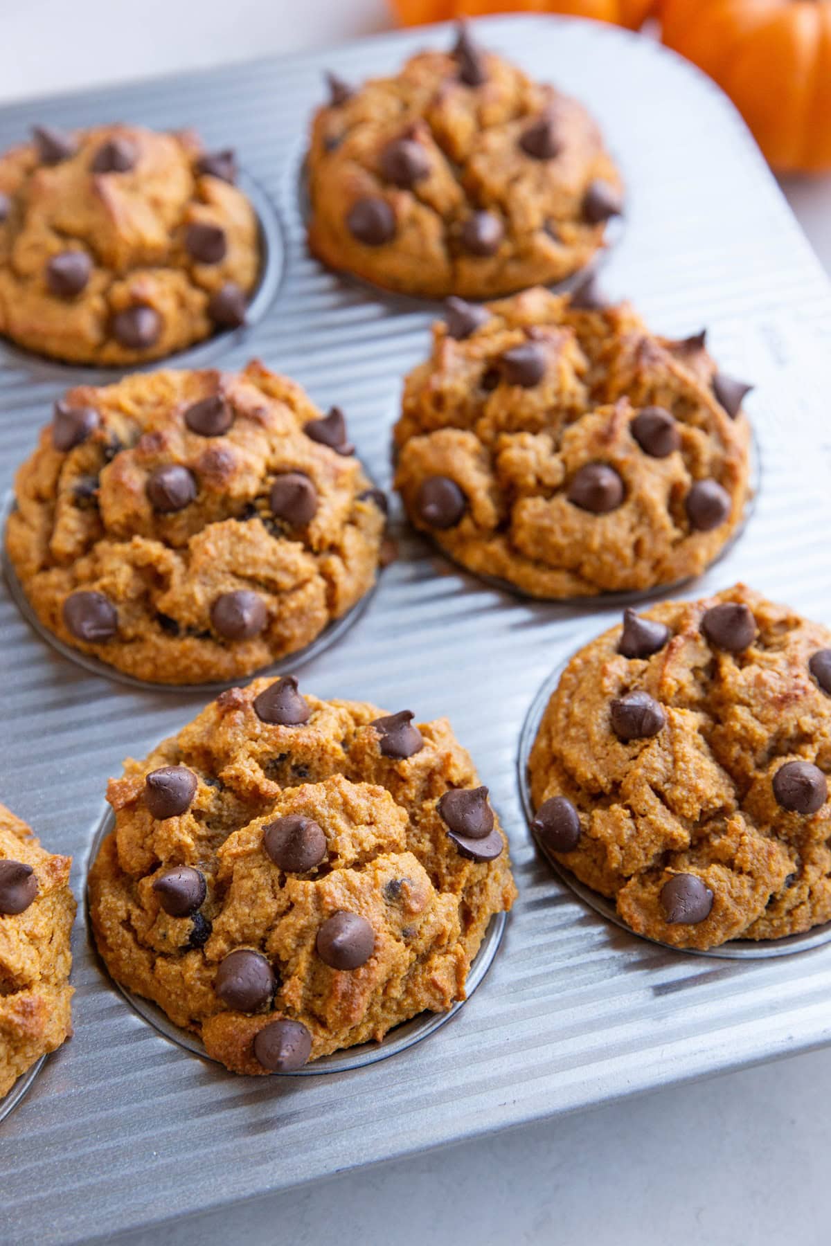 Almond flour pumpkin muffins in a muffin tray, fresh out of the oven.