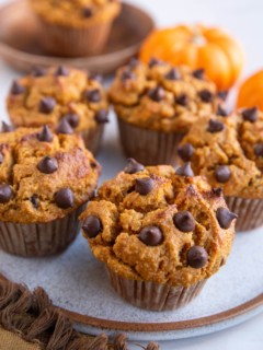 Almond Flour pumpkin muffins on a plate, ready to serve, with small pumpkins in the background.