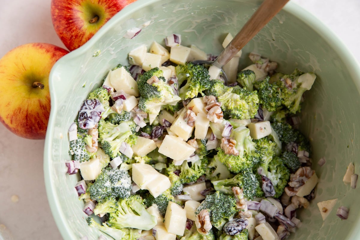 Broccoli apple salad mixed up in a mixing bowl.