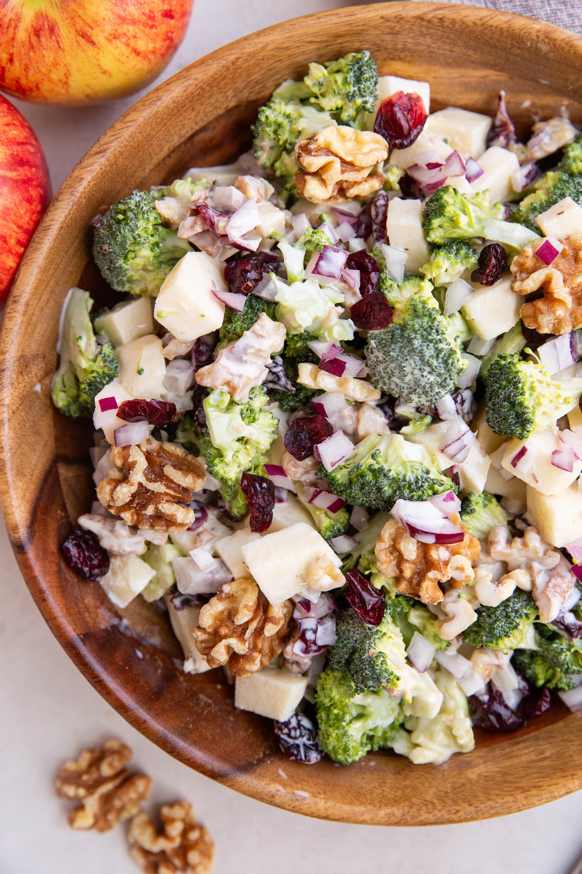 Broccoli apple salad in a wooden serving bowl, ready to eat.