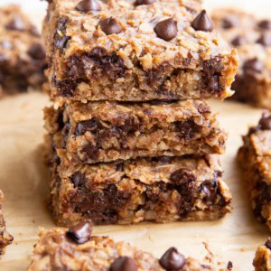 Three oatmeal peanut butter banana bars stacked on top of each other.