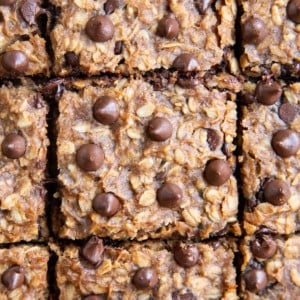 Slices of peanut butter chocolate chip banana oatmeal bars on a sheet of parchment paper.