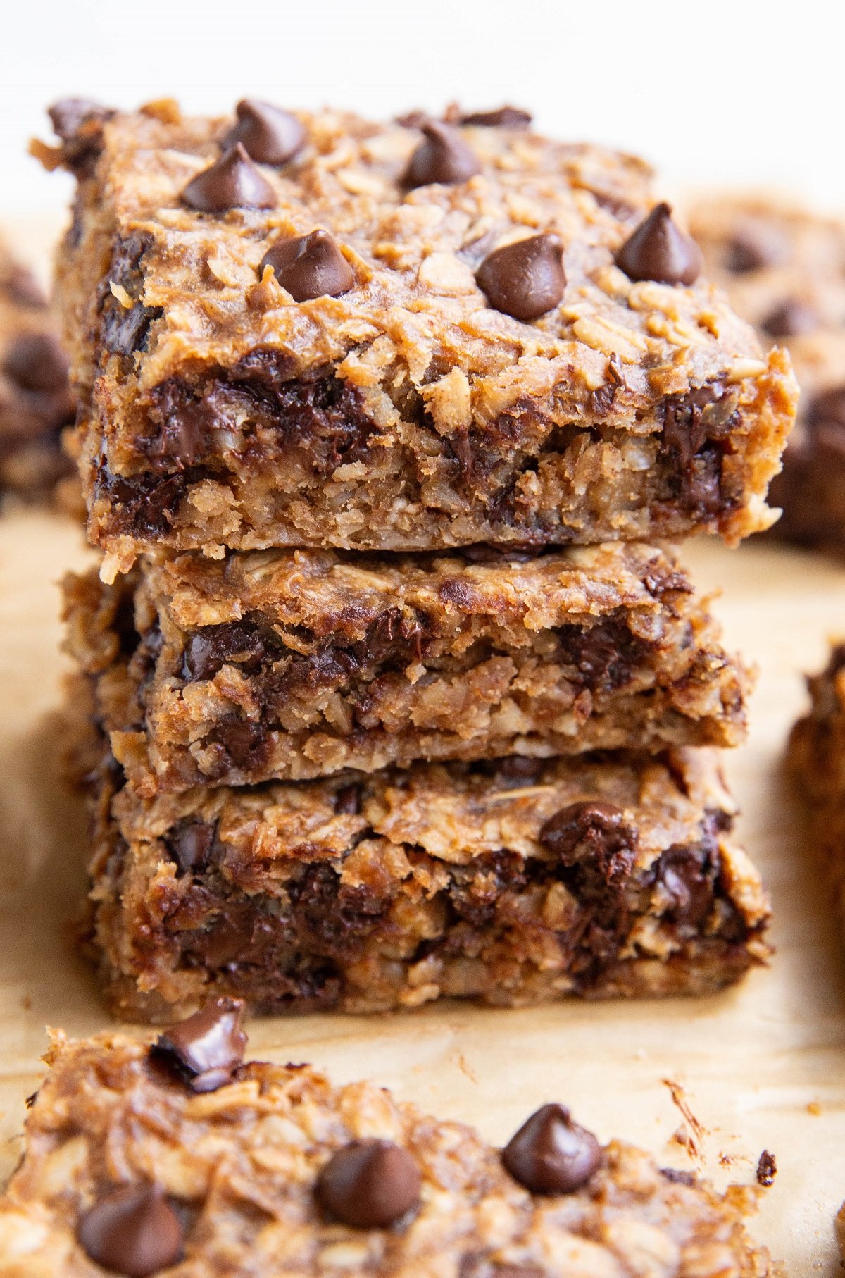 Stack of peanut butter banana oat bars on a sheet of parchment paper.